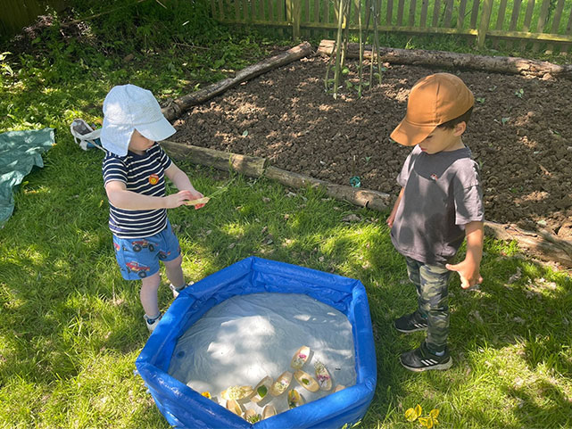 Two boys standing in front of an allotment area